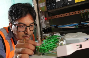 NBN technician Rajav Kapil connecting an apartment block to the National Broadband Network (NBN) in Brunswick, Melbourne, Tuesday, March 11, 2014. (AAP Image/David Crosling)