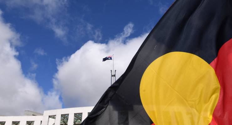 Indigenous flag outside Parliament House (Image: AAP/Lukas Coch)