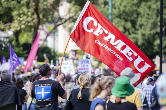 Karl Hitchcock holds the CFMEU flag at the Newcastle climate strike