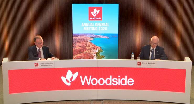 Richard Goyder and Peter Coleman conducting AGM from behind desk with Woodside logo