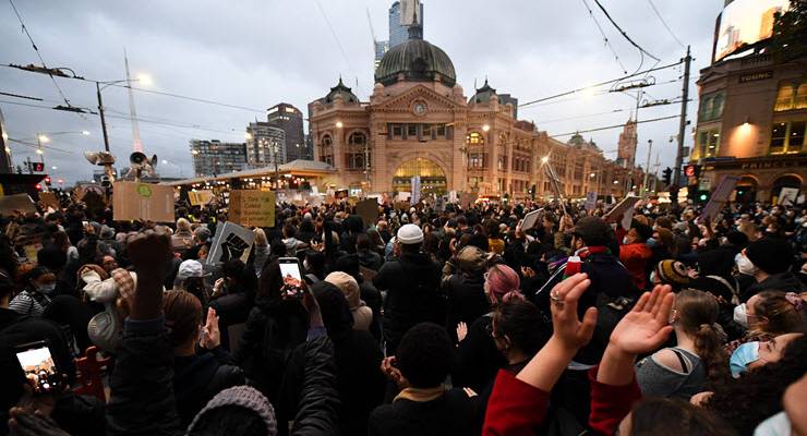 A crowd of protesters in front of Flinders St Station