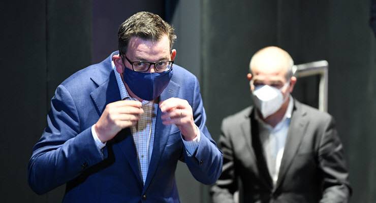daniel andrews putting on a mask
