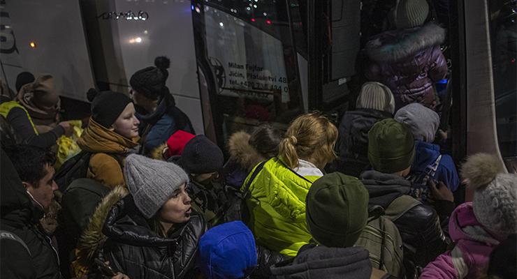 People wait to board a bus as people fleeing Ukraine arrive to Slovakia, at the border crossing in Vysne Nemecke, Slovakia, 28 February 2022. (Image: AAP/EPA/Martin Divisek)