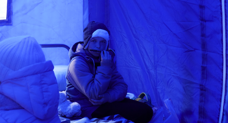 A child plays the harmonica in a refugee transit hub in Siret (Image: Amber Schultz/Private Media)