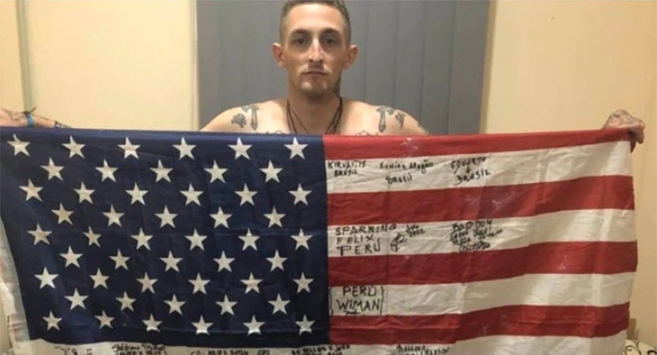 Specialist Pressley with a flag signed by members of his battalion (Image: Supplied)