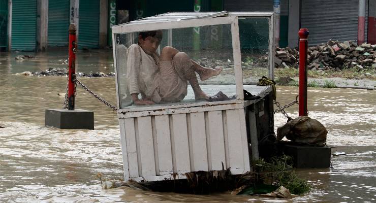 A Pakistani boy in a flooded area in Peshawar, Pakistan (Image: AAP/AP/Mohammad Sajjad)