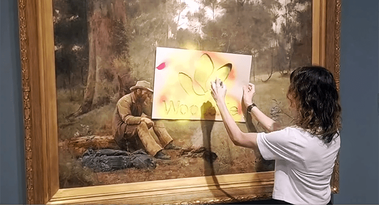 Climate activist Joana Partyka spray-paints a Frederick McCubbin painting (Image: Disrupt Burrup Hub)