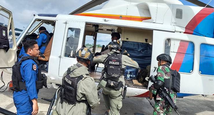 Indonesian police and military personnel boarding an helicopter during a search and rescue operation for Susi Air pilot and passengers (Image: AAP/EPA/Papua Police Headquarters)