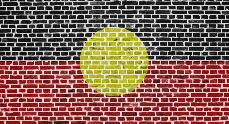 A brick wall painted with the Aboriginal flag (Image: Adobe)
