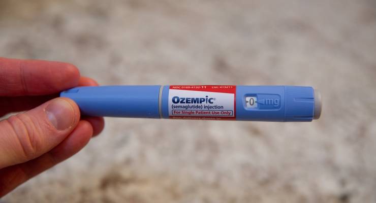 A photo illustration of an Ozempic pen seen sitting on a table