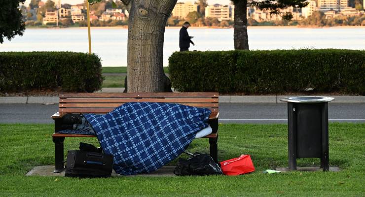 homeless person is seen sleeping on a park bench in Perth,