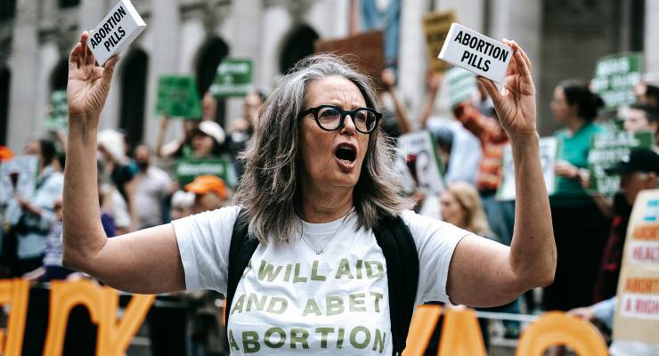 A protester holds up a box labeled "abortion pills"