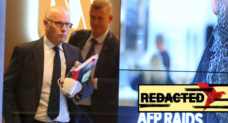 John Lyons (left), then-executive editor of ABC News, followed by an AFP officer walking out the ABC office in Sydney during the AFP raid in June 2019 (Image: AAP/David Gray)