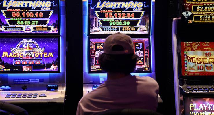 A person gambles on a poker machine at a pub in Sydney (Image: AAP/Reuters/Loren Elliott)