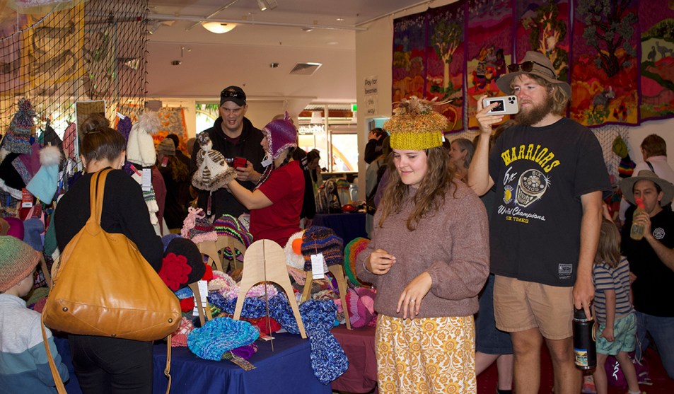 Festivalgoers try on beanies inside Beanie Central. (Image: Julia Bergin)