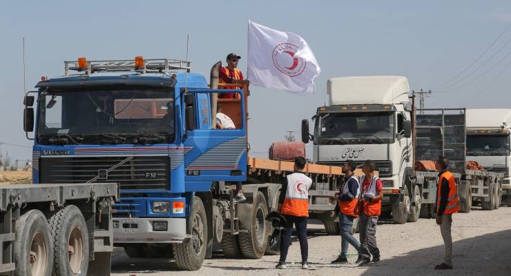 A Palestinian Red Crescent Society team hangs a flag on an aid truck at the Rafah border crossing (Image: SOPA Images/Sipa USA/Ahmed Zakot)