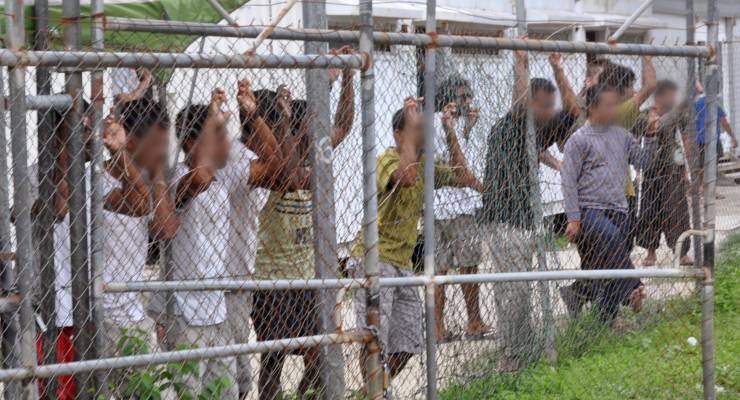 Asylum seekers behind a fence in the Manus Island detention centre in 2014 (Image: AAP/Eoin Blackwell)