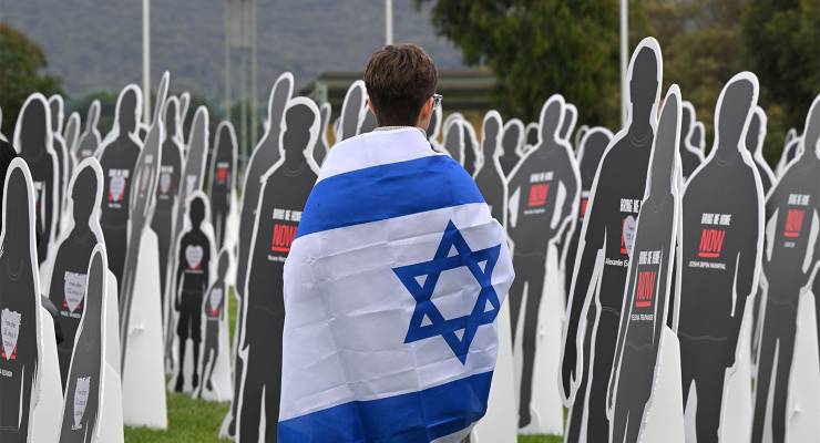 A protester with an Israeli flag outside Parliament House in Canberra (Image: AAP/Mick Tsikas)
