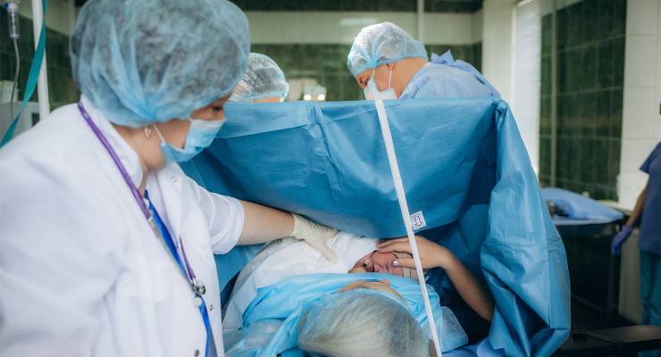 A woman and her newborn child in an operation room (Image: Adobe)