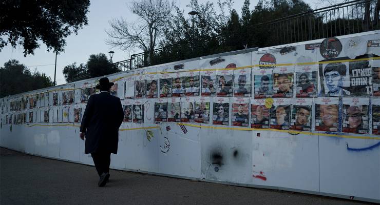 A man in Jerusalem looks at photographs of hostages abducted during the October 7 Hamas attack on Israel (Image: AAP/Leo Correa)