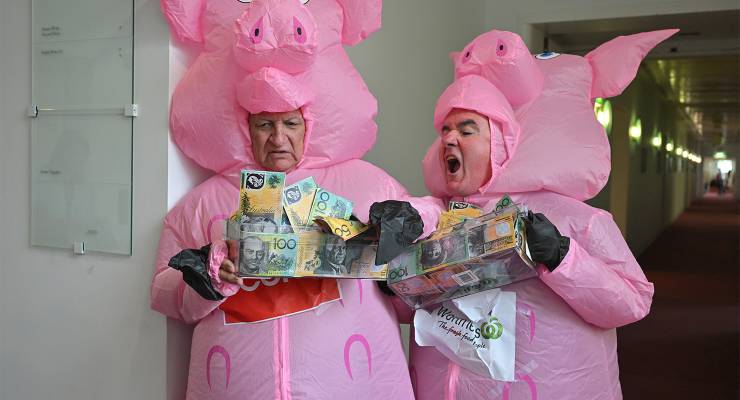 Bob Katter and Andrew Wilkie dressed as pigs to highlight the market dominance of the big supermarkets (Image: AAP/Mick Tsikas)